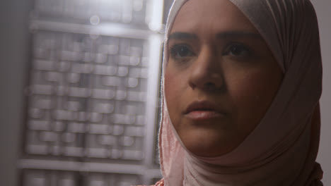 Studio-Head-And-Shoulders-Portrait-Of-Muslim-Woman-Wearing-Hijab-Praying-In-Mosque-Or-At-Home